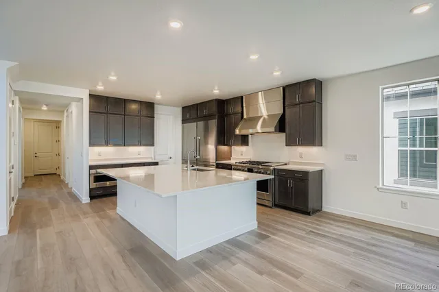 a large kitchen with stainless steel appliances granite countertop a stove and a refrigerator