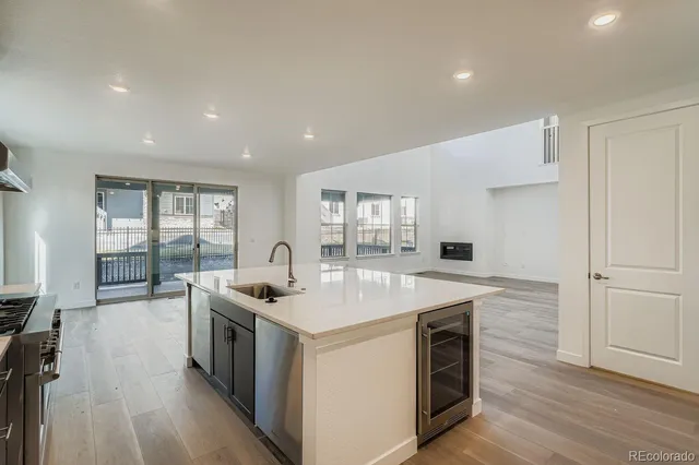 a kitchen that has a sink a stove and wooden floor