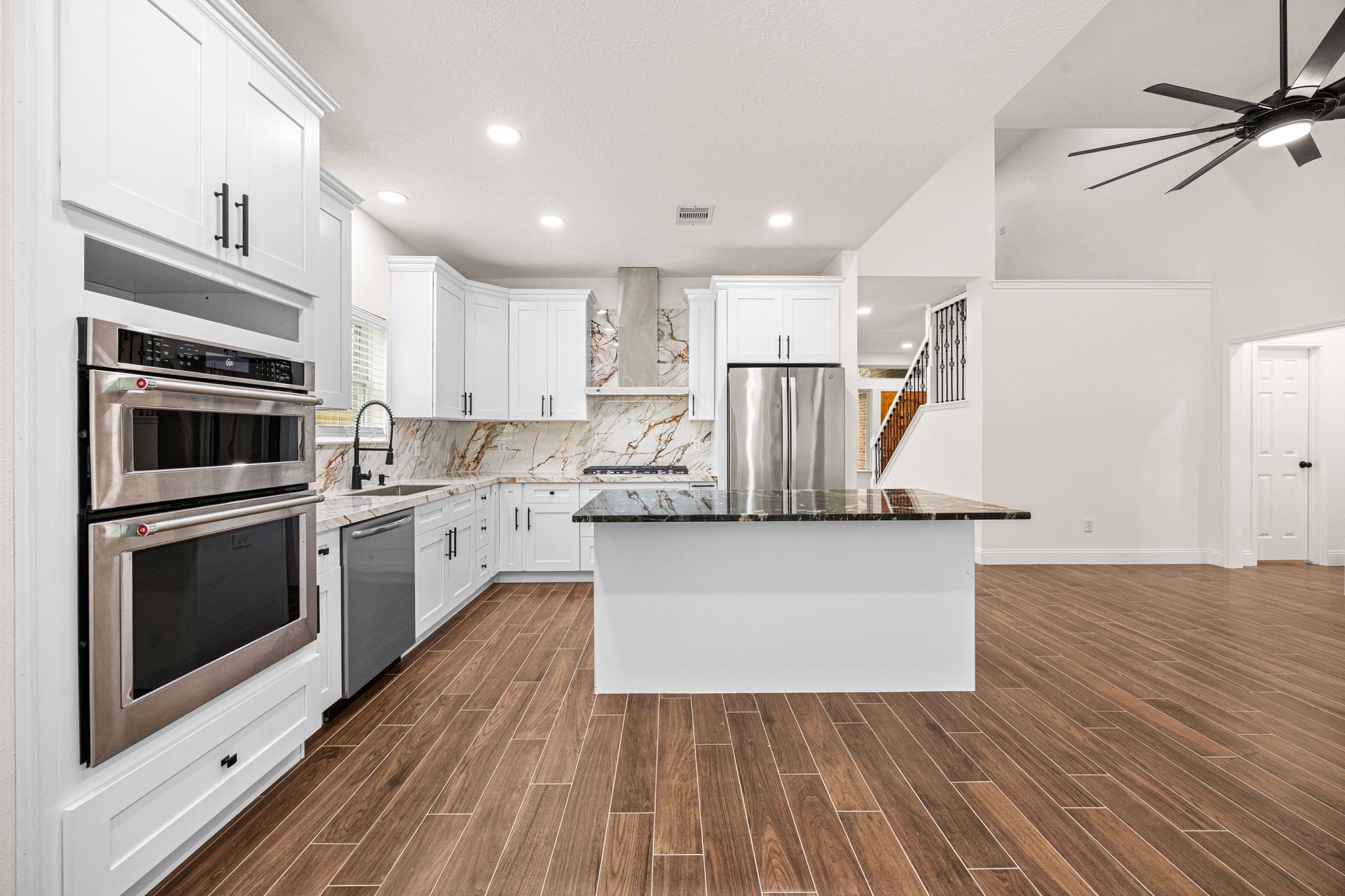 17907 Pelican Way Road Houston, TX 77084 - Photo 14 of 39 a kitchen with kitchen island wooden floors white cabinets appliances and cabinets