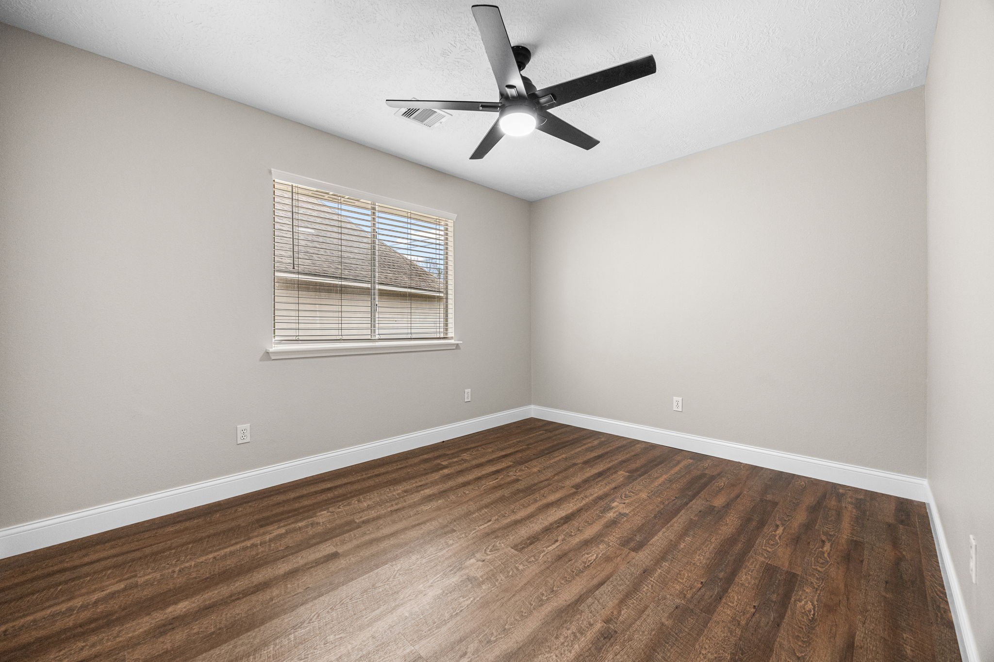 17907 Pelican Way Road Houston, TX 77084 - Photo 32 of 39 an empty room with wooden floor ceiling fan and windows