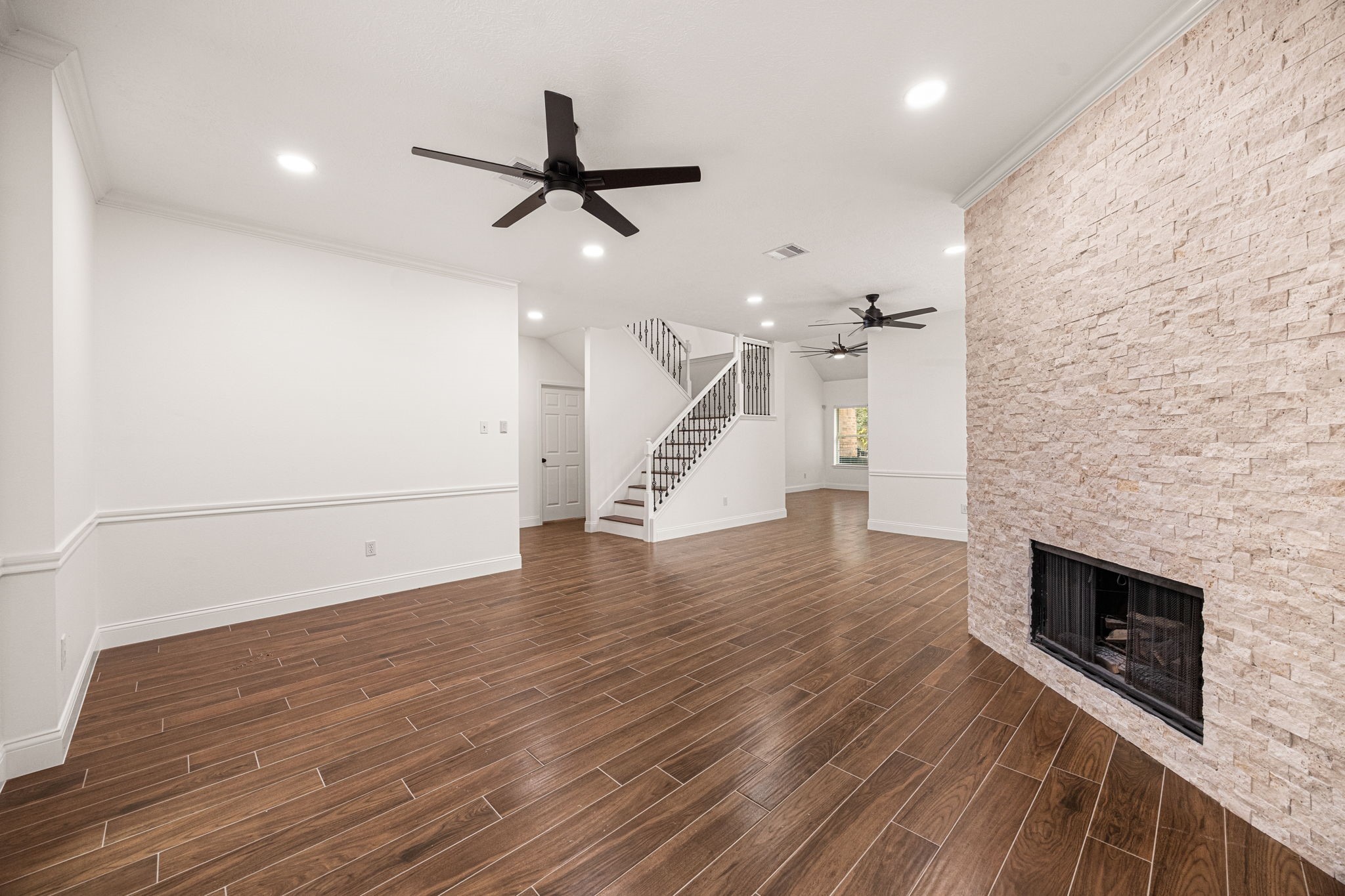 17907 Pelican Way Road Houston, TX 77084 - Photo 9 of 39 an empty room with wooden floor fireplace and windows