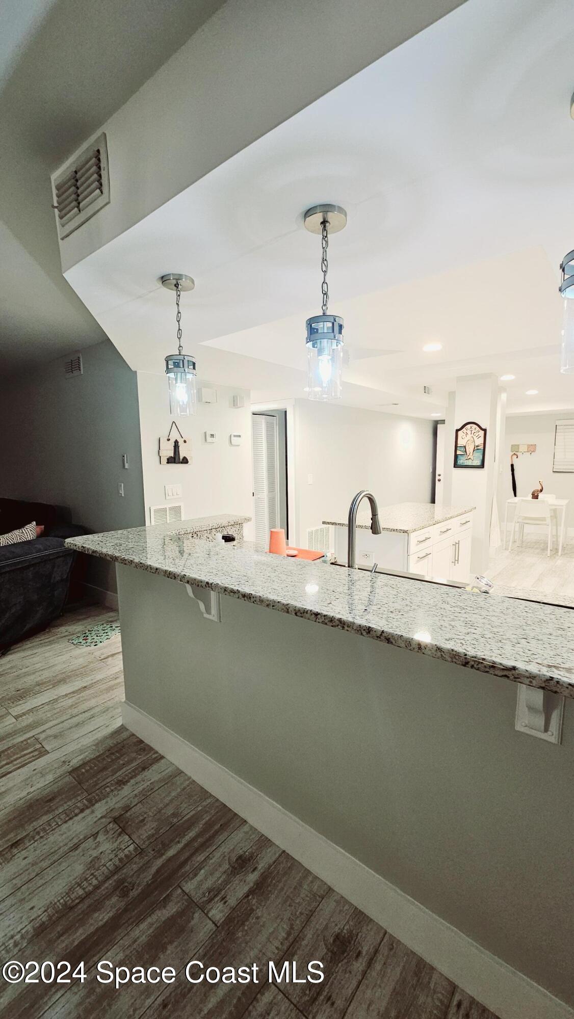 650 North Atlantic Avenue, Unit 109 Cocoa Beach, FL 32931 - Photo 12 of 36 a view of a sink and a wooden floor