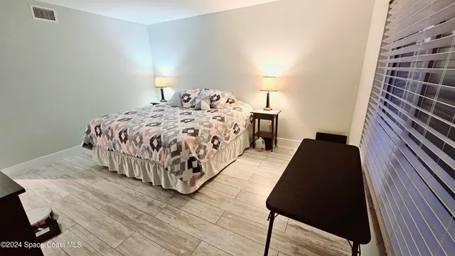 a bed sitting in a bedroom next to a lamp