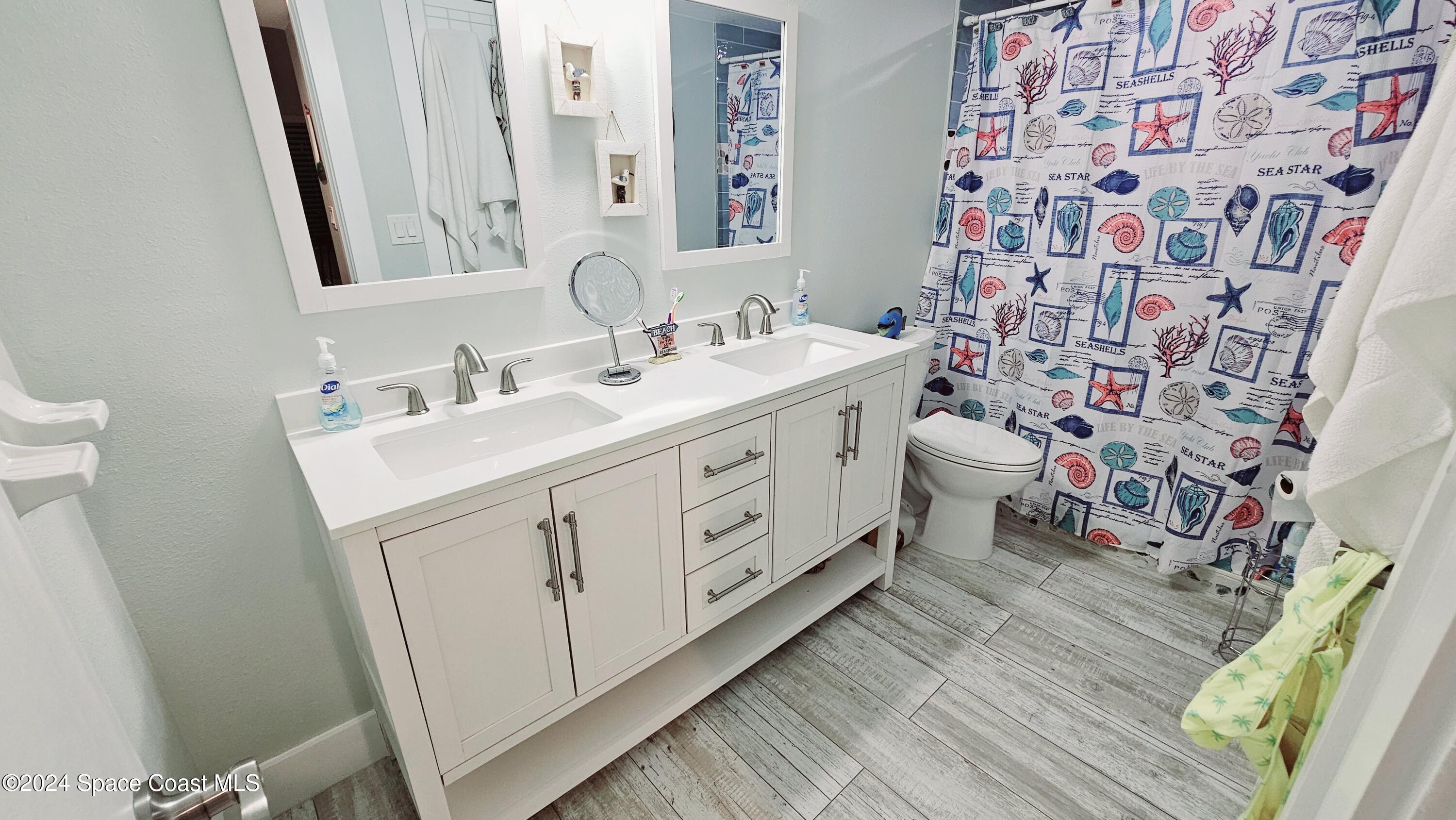 650 North Atlantic Avenue, Unit 109 Cocoa Beach, FL 32931 - Photo 17 of 36 a bathroom with a double vanity sink and a mirror