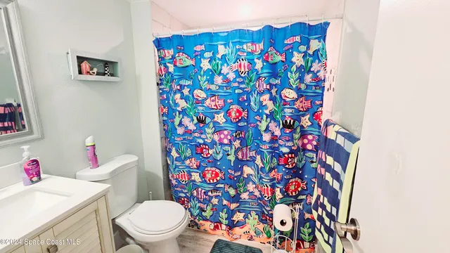 a white toilet sitting next to a sink