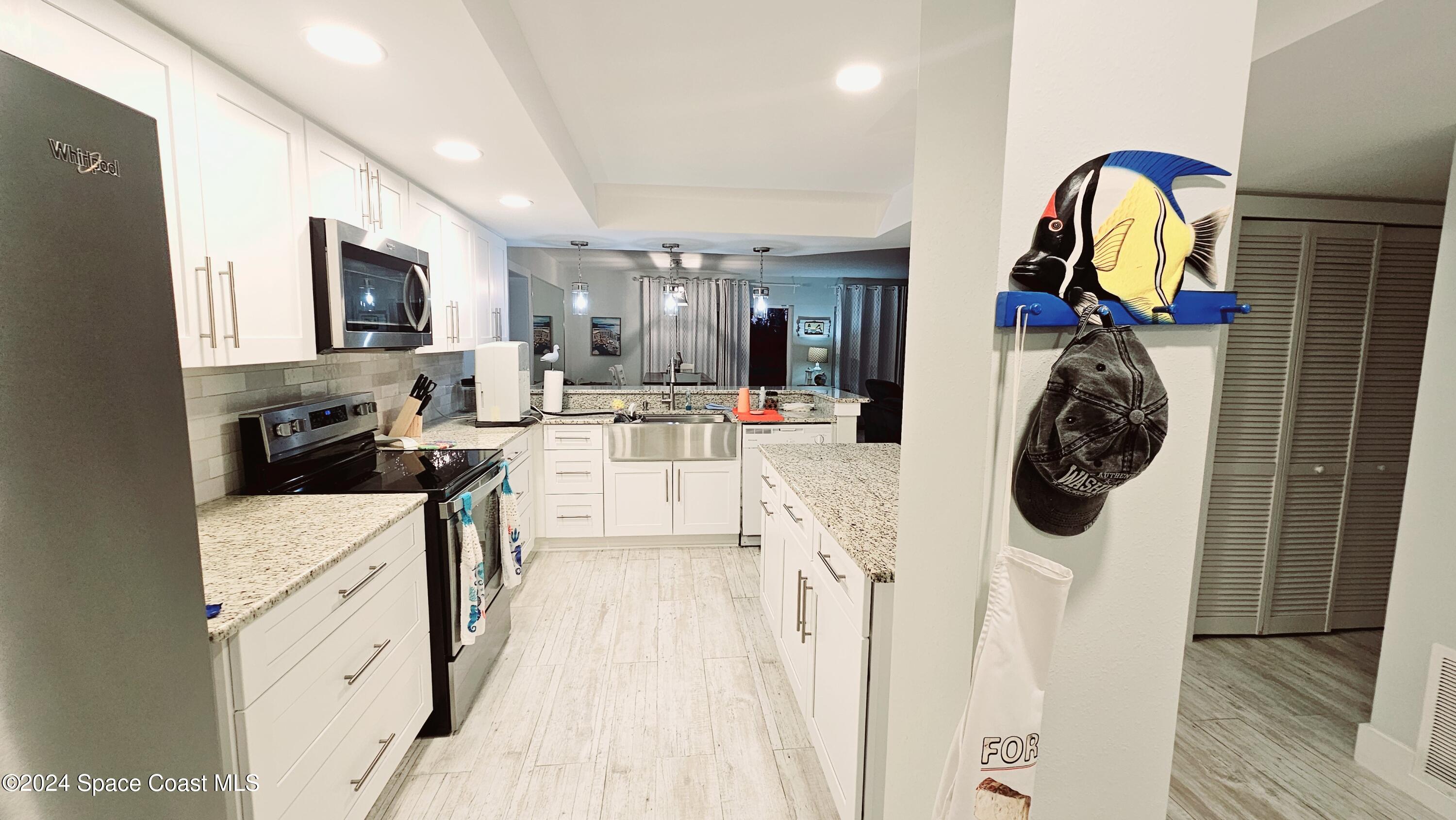 650 North Atlantic Avenue, Unit 109 Cocoa Beach, FL 32931 - Photo 9 of 36 a view of a kitchen with appliances and cabinets