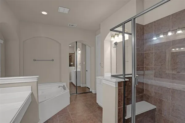 a bathroom with a tub shower vanity and a sink