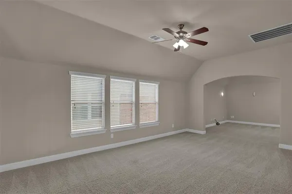 a view of an empty room with a ceiling fan and window