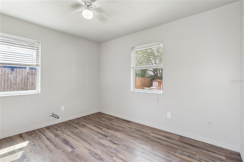 7208 Fair Oaks Street Spring Hill, FL 34606 - Photo 13 of 25 a view of empty room with wooden floor and fan