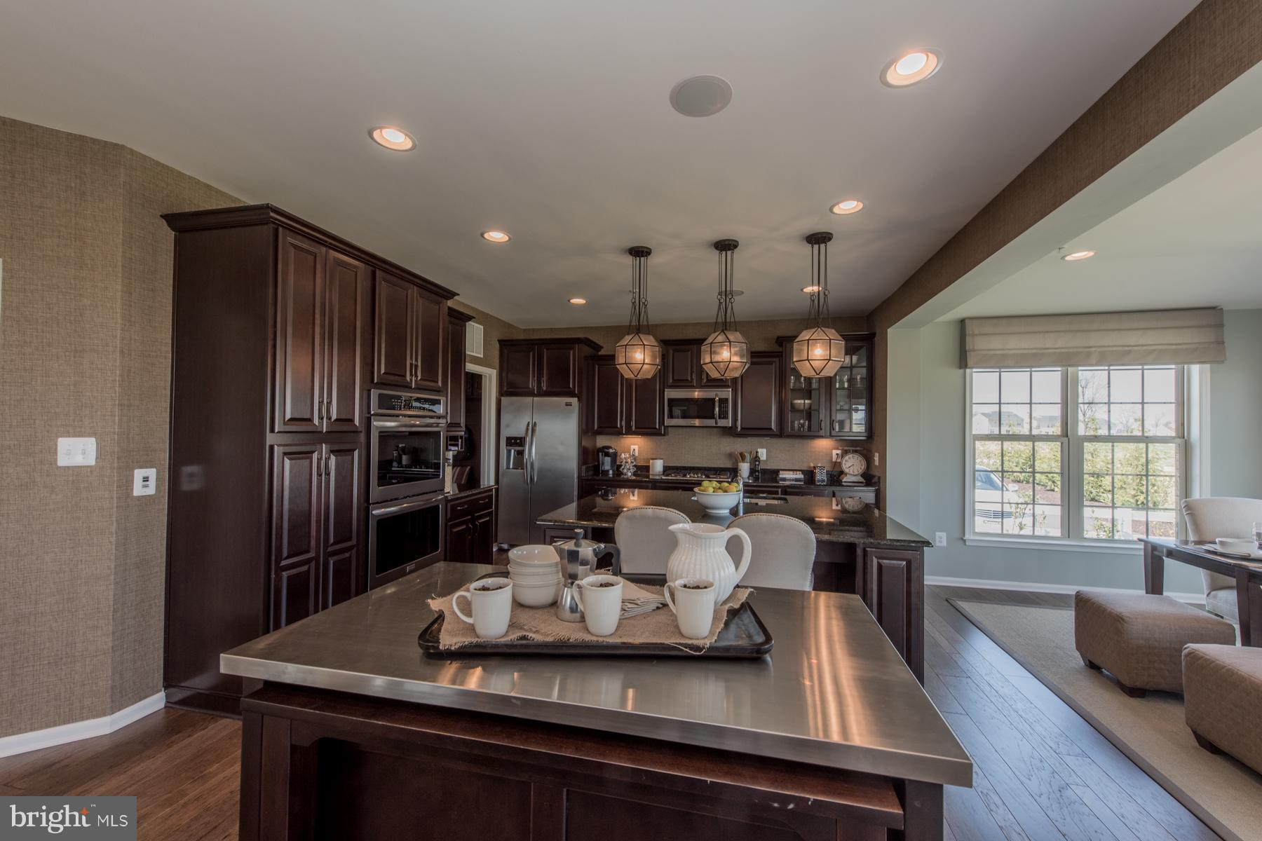 9772 Powder Hall Road Perry Hall, MD 21128 - Photo 11 of 28 a kitchen with kitchen island a large counter top space a sink stainless steel appliances and cabinets