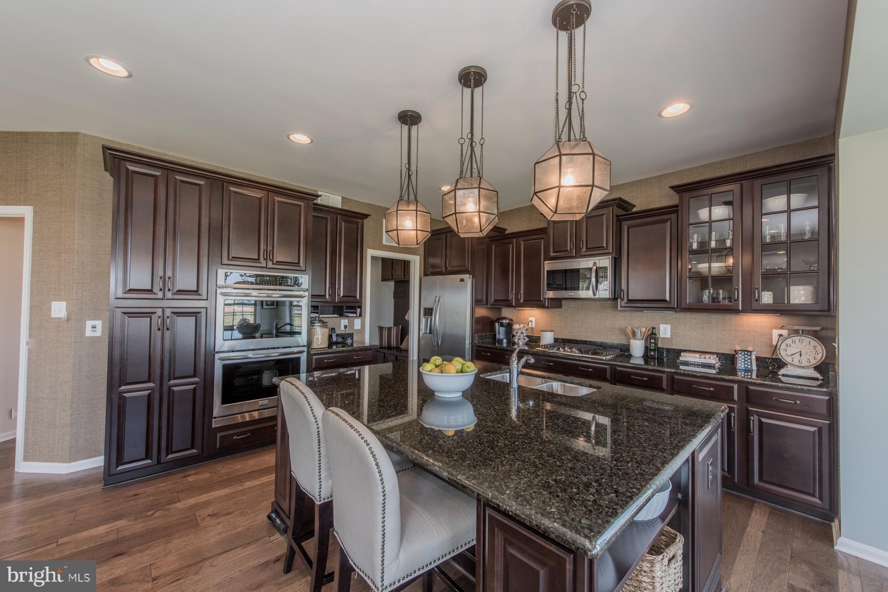 9772 Powder Hall Road Perry Hall, MD 21128 - Photo 14 of 28 a kitchen with stainless steel appliances granite countertop a sink a stove and chairs
