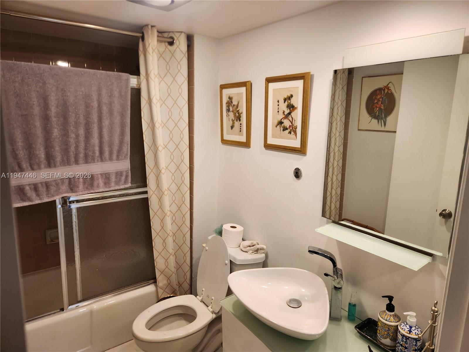 1925 Brickell Avenue, Unit 1411 Miami, FL 33129 - Photo 18 of 52 a bathroom with a toilet a sink and mirror