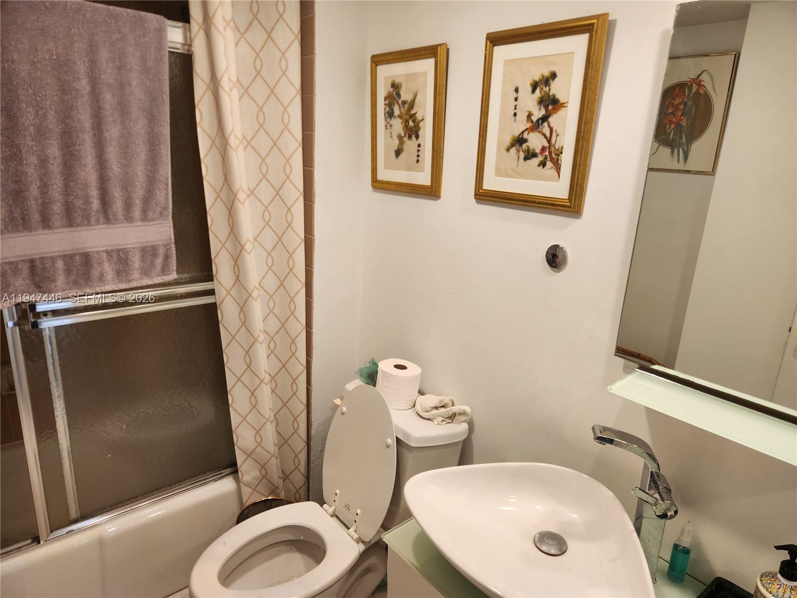 1925 Brickell Avenue, Unit 1411 Miami, FL 33129 - Photo 19 of 52 a bathroom with a toilet sink and mirror