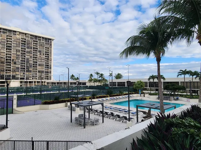 a roof deck with table and chairs and potted plants