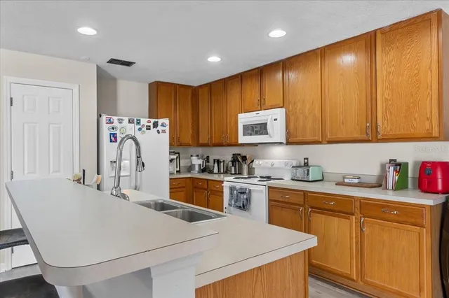 a kitchen with stainless steel appliances granite countertop a sink a stove a refrigerator and cabinets