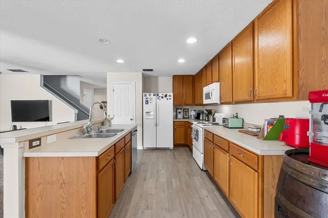 a kitchen with stainless steel appliances granite countertop a sink stove refrigerator and cabinets