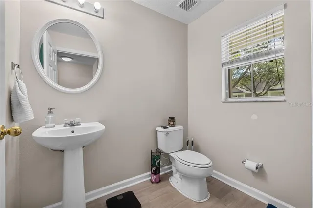 a bathroom with a toilet a sink and a mirror
