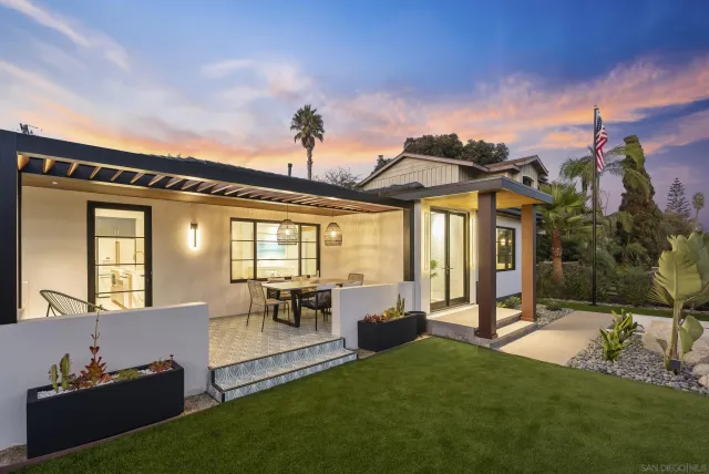 a view of a house with furniture and a yard