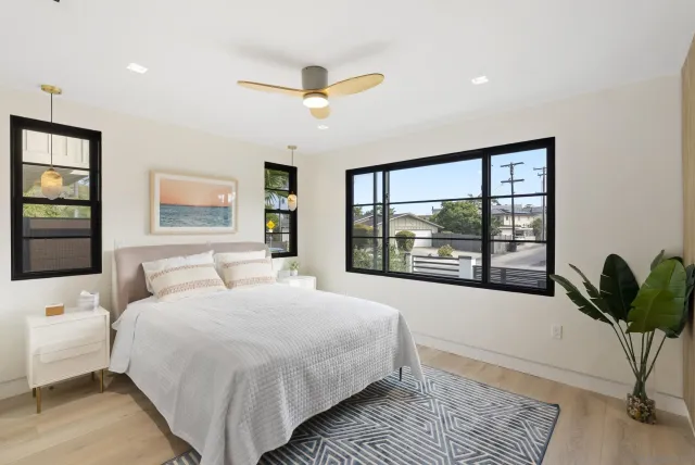 a bedroom with a large bed and a potted plant