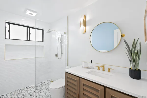 a bathroom with a granite countertop sink a toilet and a mirror