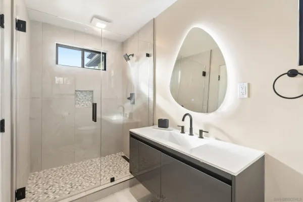 a bathroom with a sink a mirror and a shower