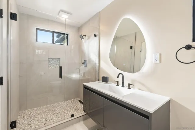 a bathroom with a sink a mirror and a shower