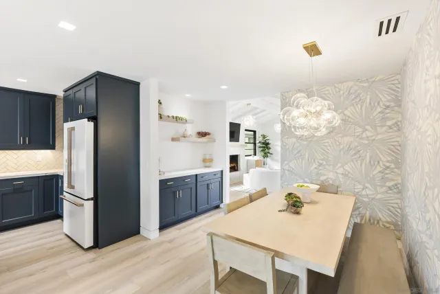 a kitchen with stainless steel appliances kitchen island granite countertop a refrigerator a stove and a sink with wooden floor