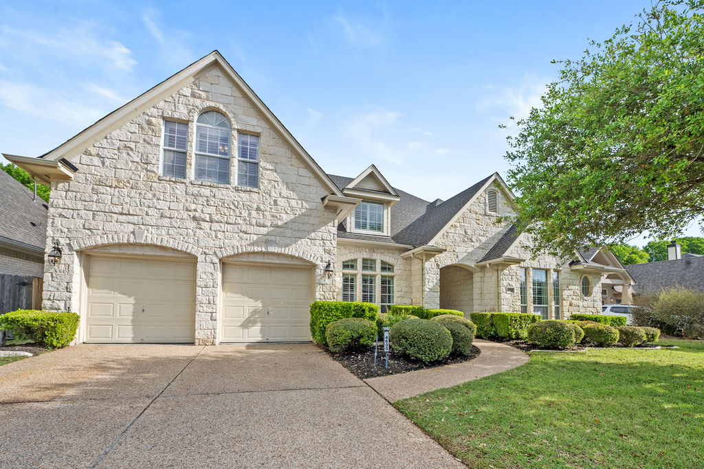 a front view of a house with a garden and plants