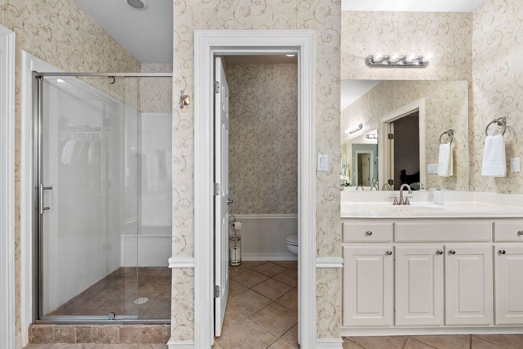 4600 Slickrock Cove Austin, TX 78747 - Photo 25 of 40 a bathroom with a granite countertop sink two mirror and shower