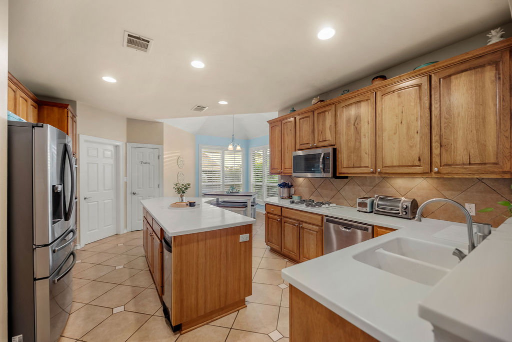 4600 Slickrock Cove Austin, TX 78747 - Photo 3 of 40 a kitchen with stainless steel appliances granite countertop a sink stove refrigerator and cabinets