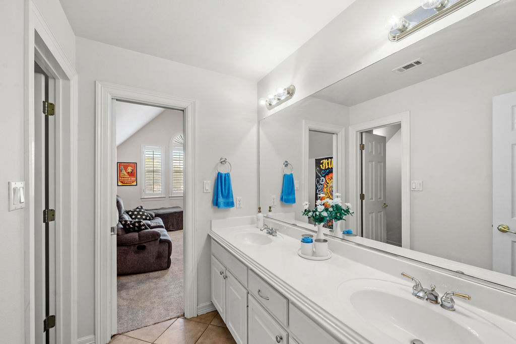 4600 Slickrock Cove Austin, TX 78747 - Photo 31 of 40 a en suite bathroom with a double vanity sink and mirror