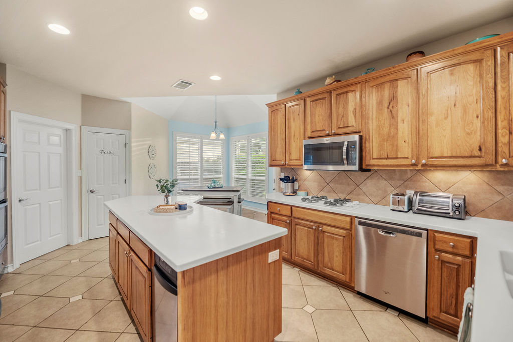 4600 Slickrock Cove Austin, TX 78747 - Photo 4 of 40 a kitchen with stainless steel appliances a sink stove and cabinets