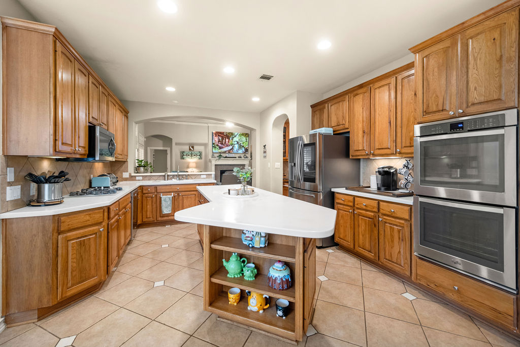 4600 Slickrock Cove Austin, TX 78747 - Photo 7 of 40 a large kitchen with stainless steel appliances granite countertop a stove a sink dishwasher and a microwave oven with cabinets