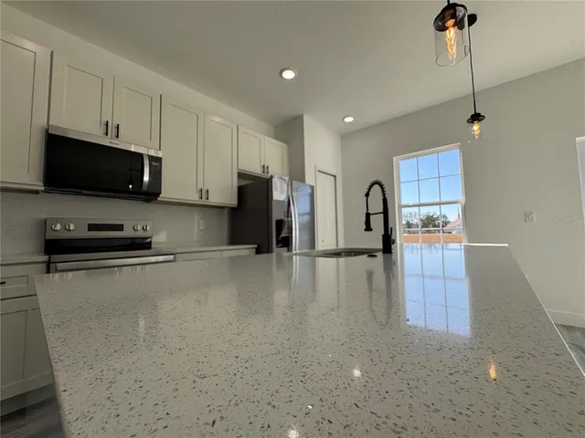 a kitchen with stainless steel appliances a refrigerator a stove a microwave and cabinets