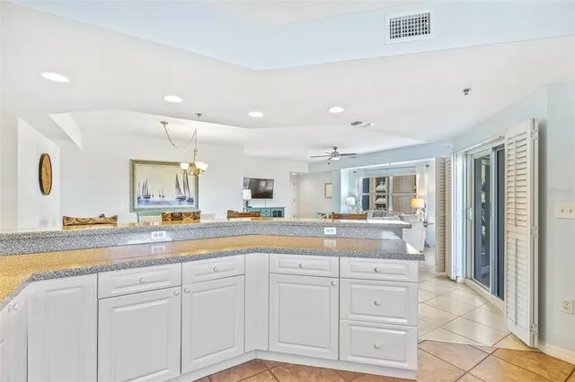 a kitchen with white cabinets and sink