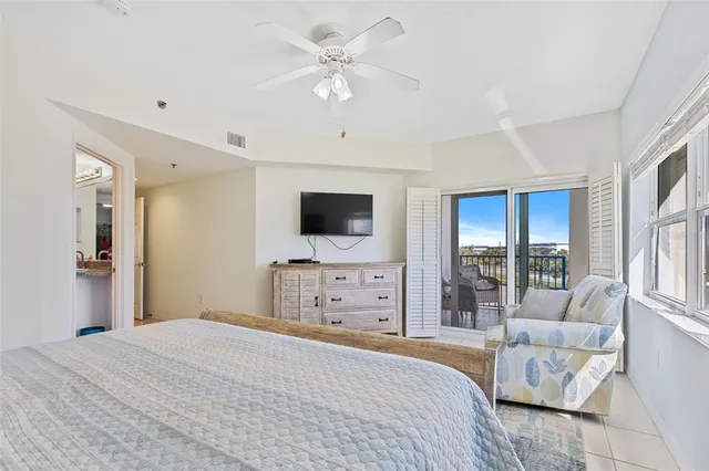 a bedroom with a large bed a flat tv screen and a couch