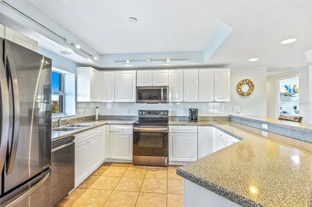 a kitchen with a sink stainless steel appliances and window