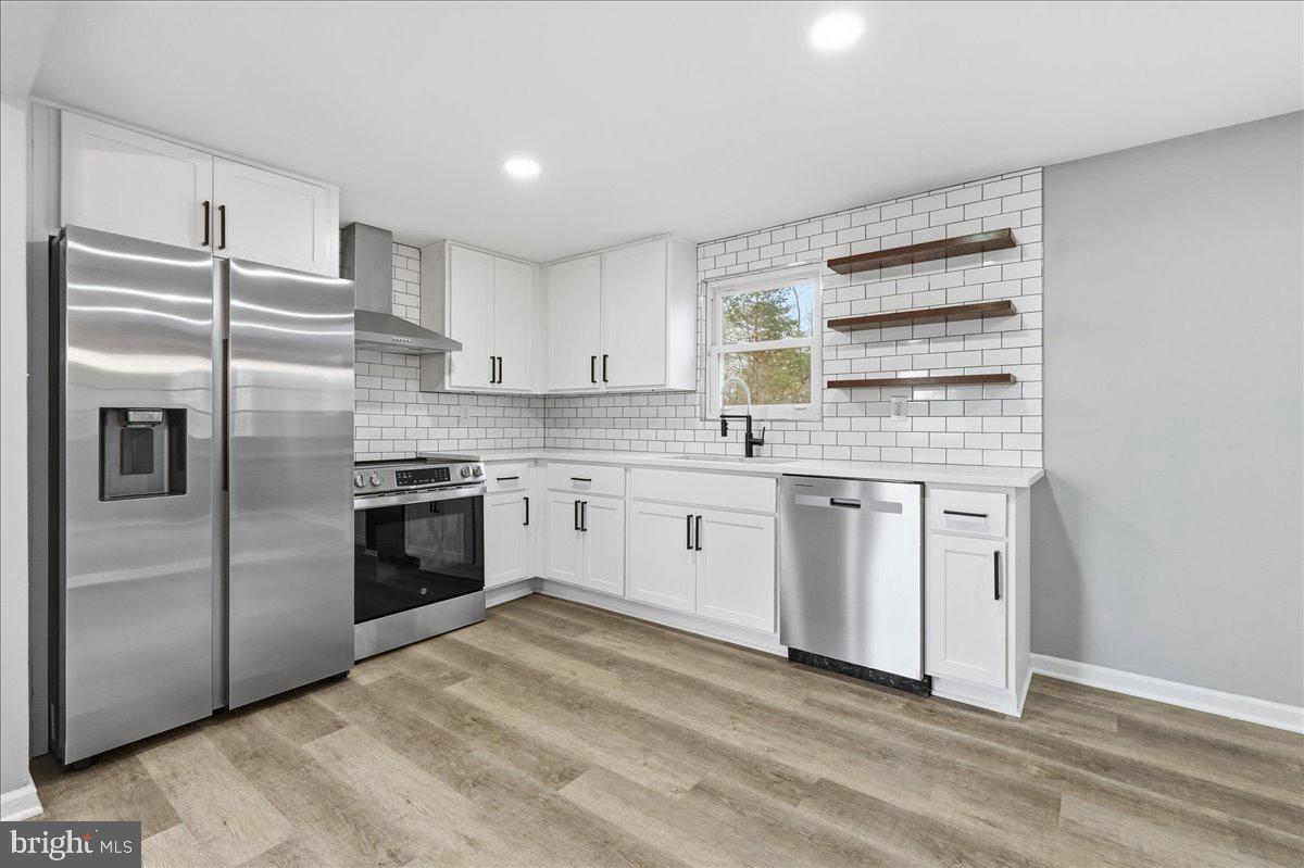 8710 Sum Place Charlotte Hall, MD 20622 - Photo 11 of 30 a kitchen with a refrigerator stove and white cabinets