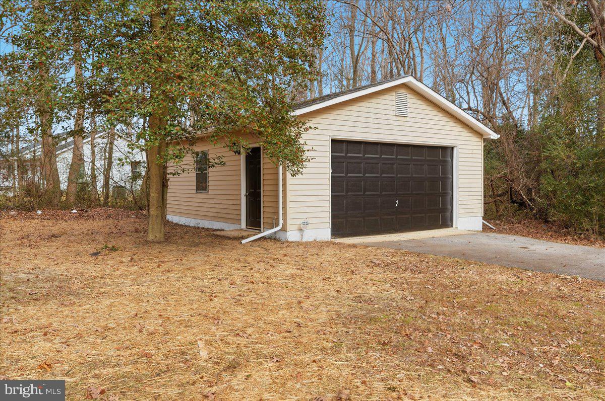 8710 Sum Place Charlotte Hall, MD 20622 - Photo 24 of 30 a front view of a house with a yard and garage