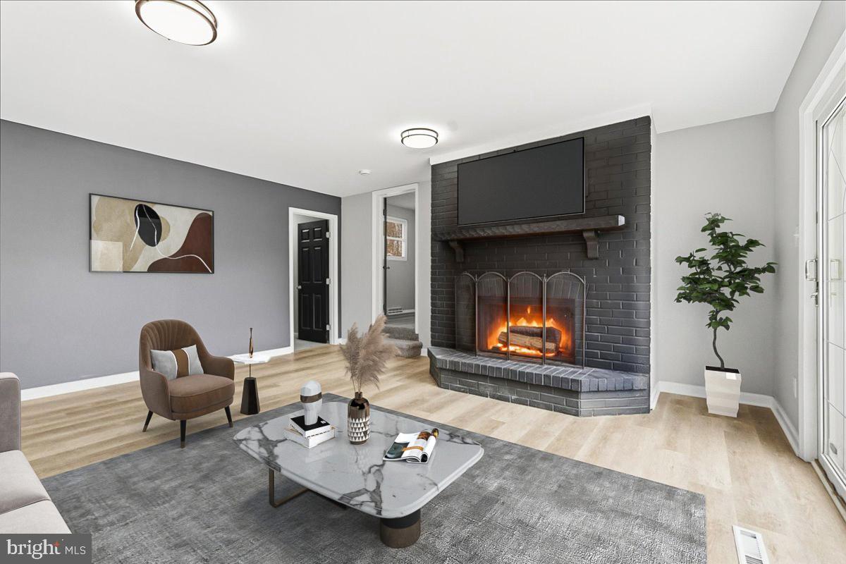 8710 Sum Place Charlotte Hall, MD 20622 - Photo 3 of 30 a living room with furniture a fireplace and a potted plant