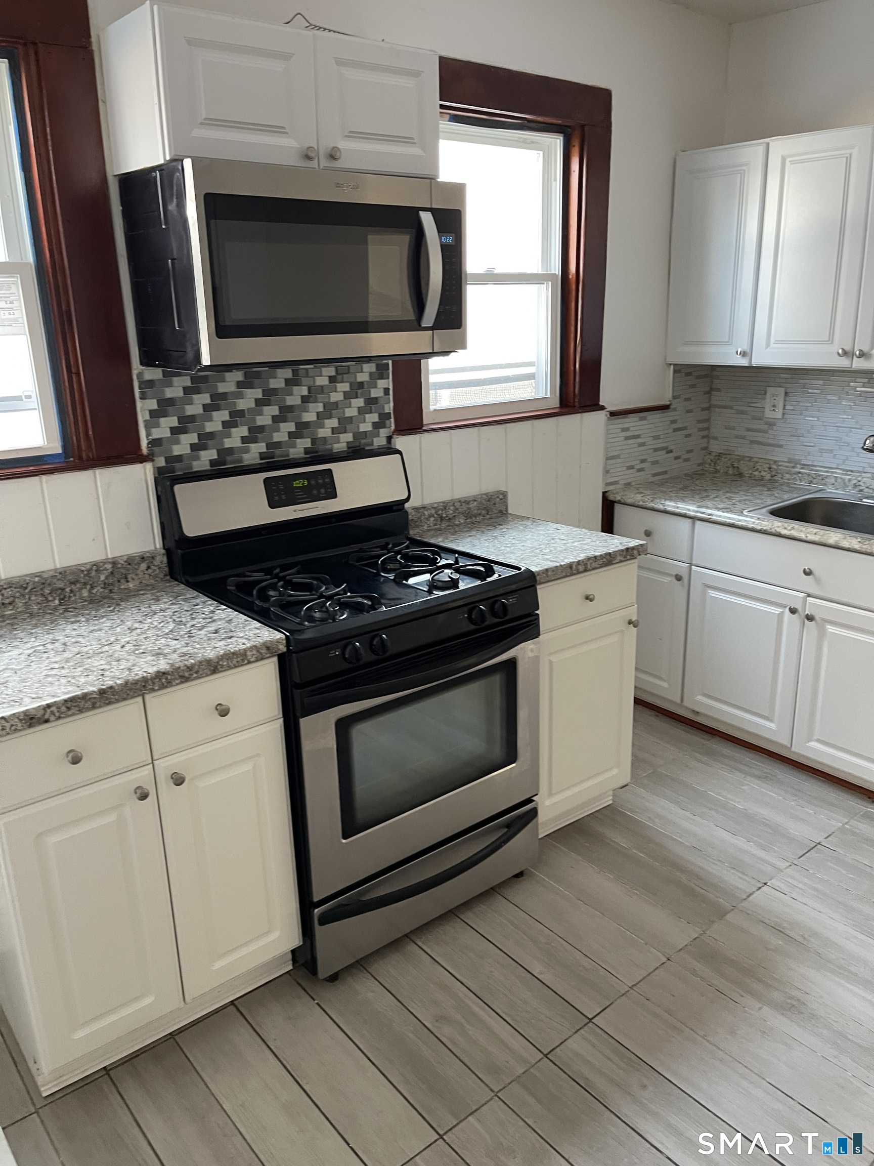 191 Parrott Avenue, Unit 1 Bridgeport, CT 06606 - Photo 2 of 9 a kitchen with granite countertop stainless steel appliances a stove sink and microwave