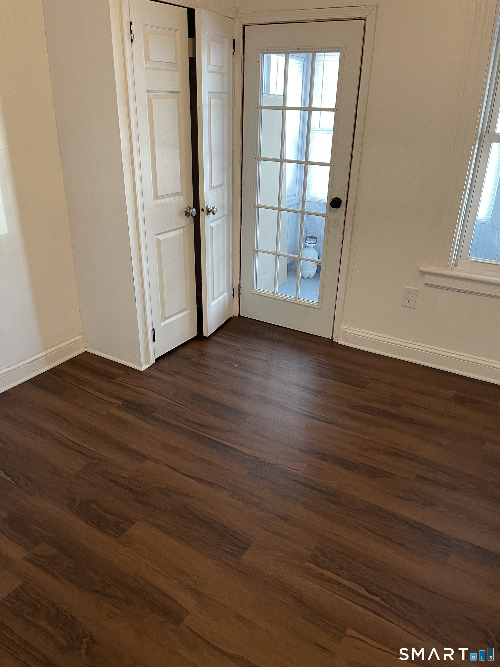 191 Parrott Avenue, Unit 1 Bridgeport, CT 06606 - Photo 8 of 9 an empty room with wooden floor and windows