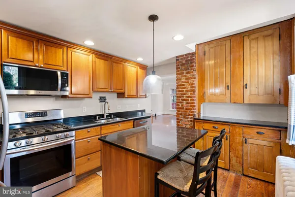 a kitchen with granite countertop a sink a stove and cabinets