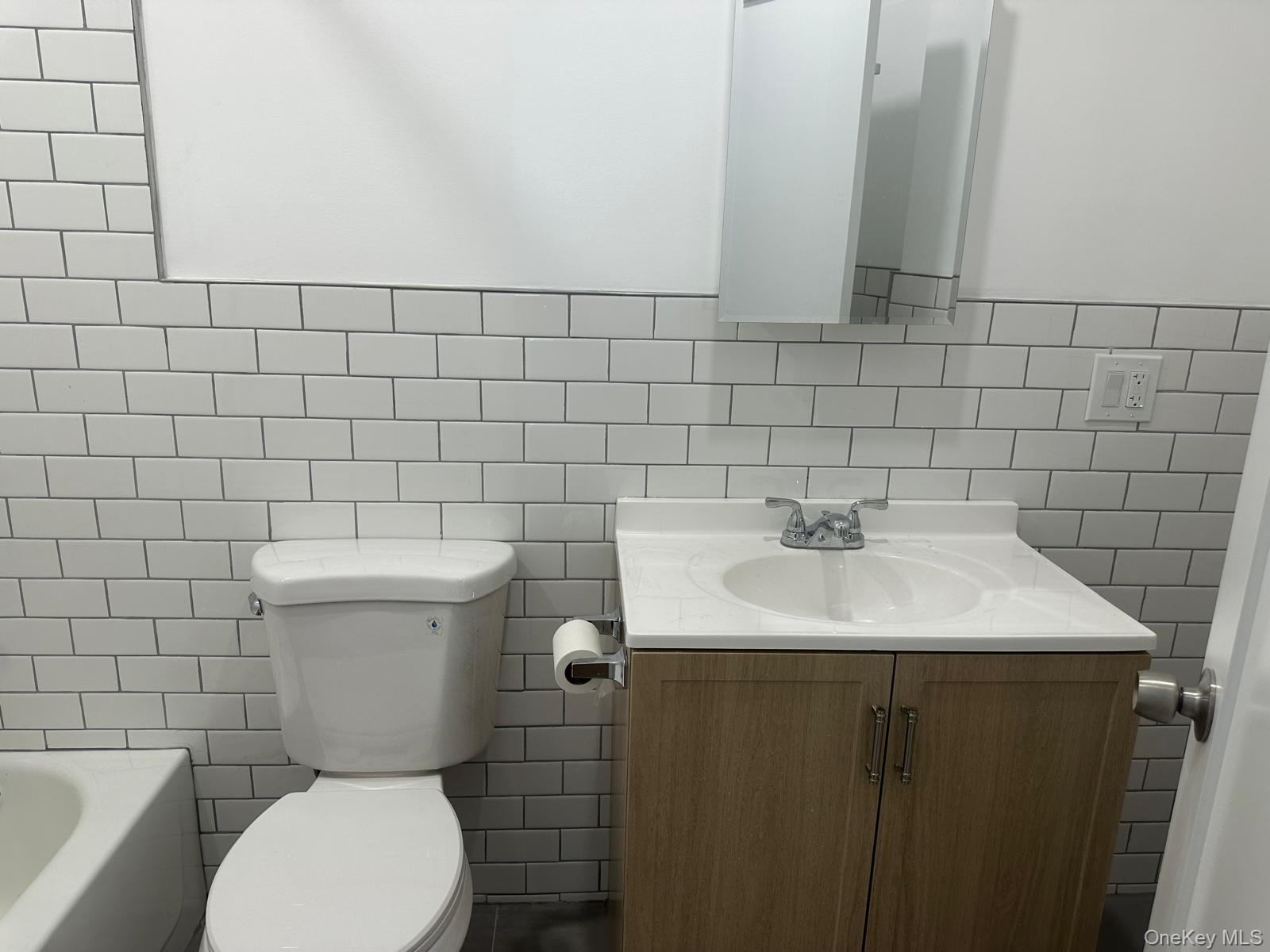54-01 108th Street, Unit 2F Queens, NY 11368 - Photo 3 of 5 a bathroom with a toilet sink and mirror