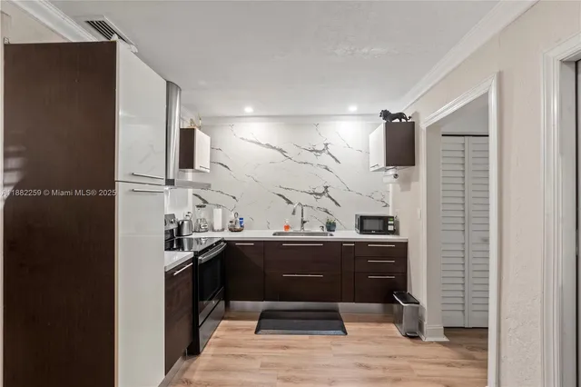 a kitchen with granite countertop a sink and a refrigerator