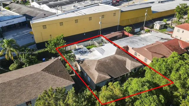 a view of a backyard with plants and wooden fence