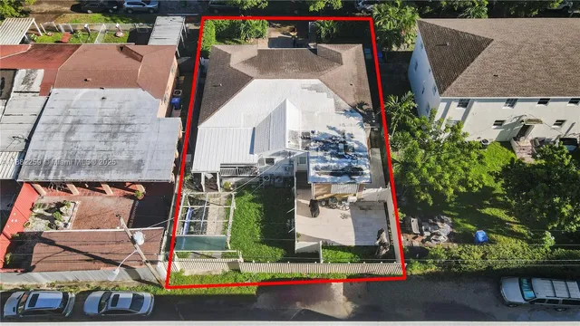 an aerial view of residential houses with outdoor space and trees
