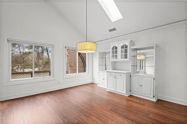 a hallway with wooden floors and chandelier