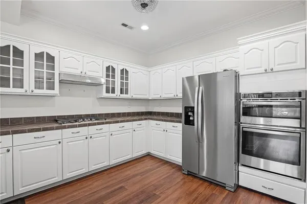 a kitchen with granite countertop stainless steel appliances and wooden floor