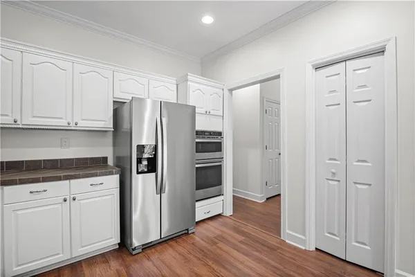 a kitchen with stainless steel appliances wooden floors and wooden cabinets